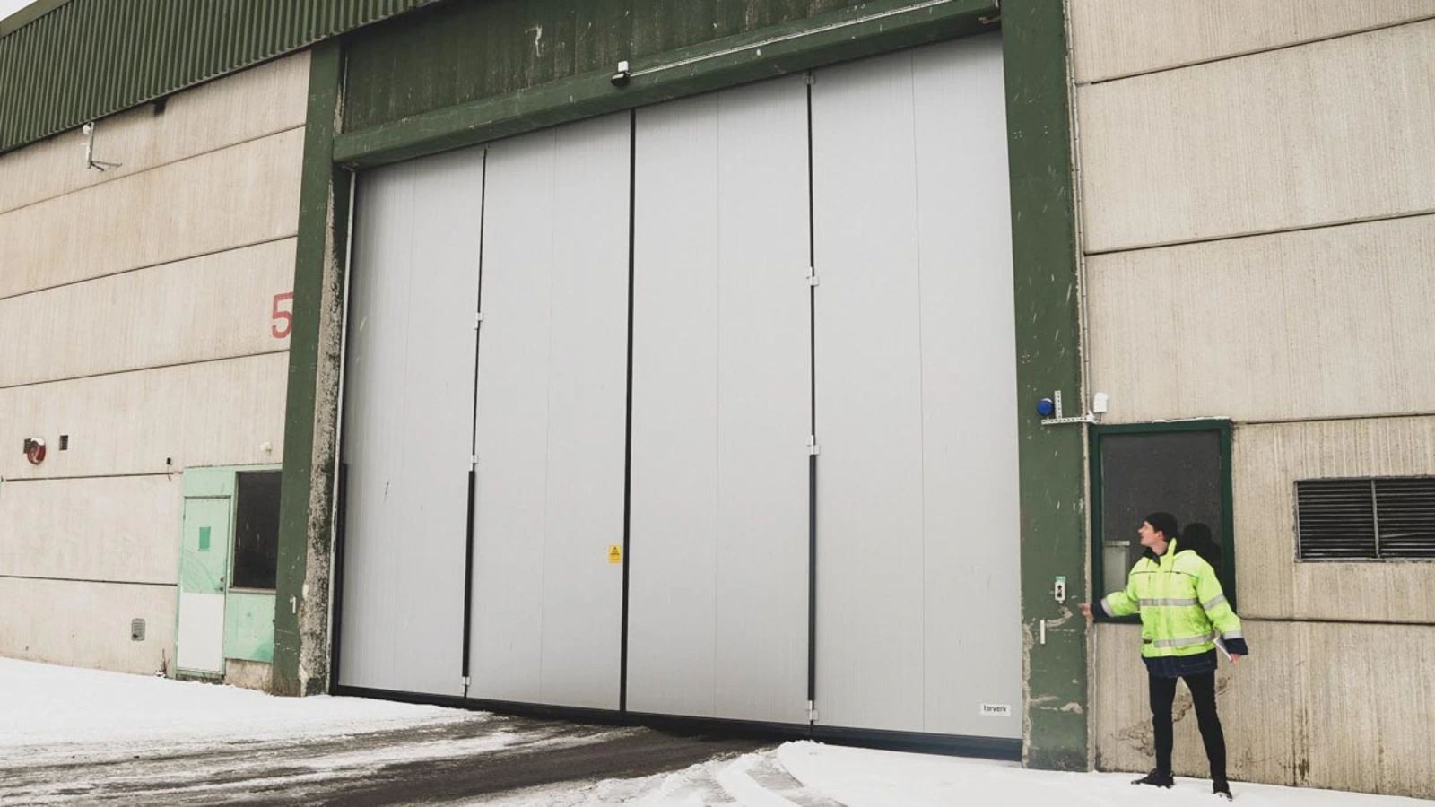 Vänerhamn replaced vertical fabric doors with bi-folding doors, which cost less to maintain and get hit less often because they open sideways in both directions at once