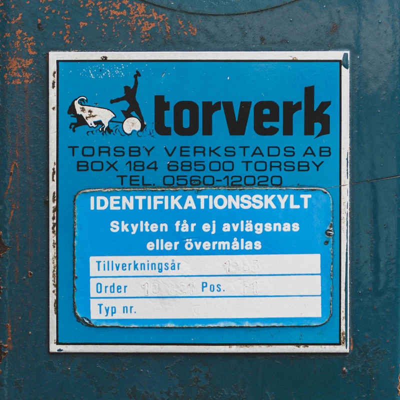 Id-skylt för vikport som visar att den är monterad 1985