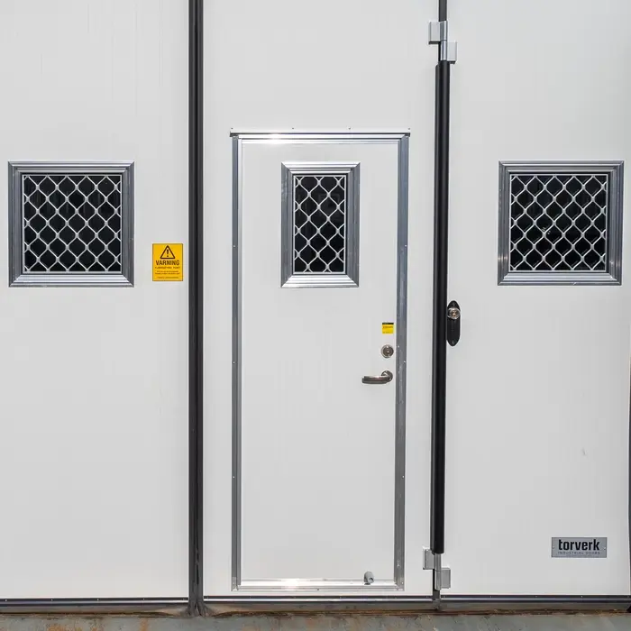 Visar gångdörren i en Torverk Q-Door FX, med armerade fönster för ökad inbrottssäkerhet.